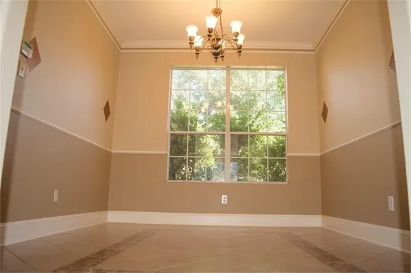 an empty room with windows outdoor and kitchen view