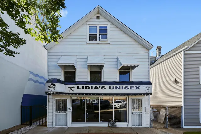 a view of a house with large windows and a small yard