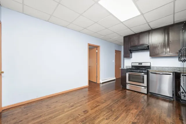 a kitchen with granite countertop wooden floors and stainless steel appliances