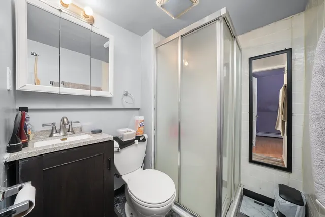 a bathroom with a toilet sink vanity and mirror