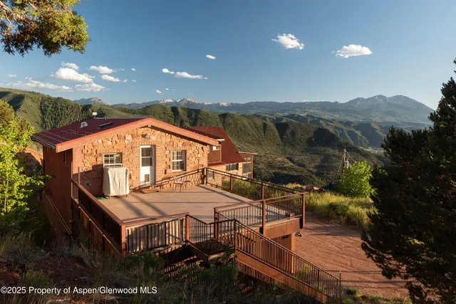 a view of a balcony with chairs and wooden floor