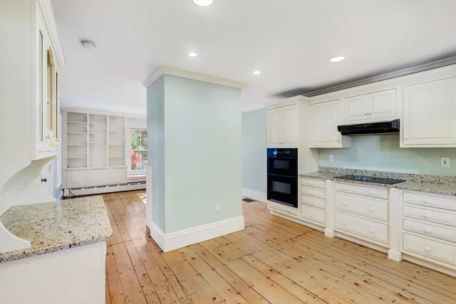 a kitchen with granite countertop a sink and a stove top oven