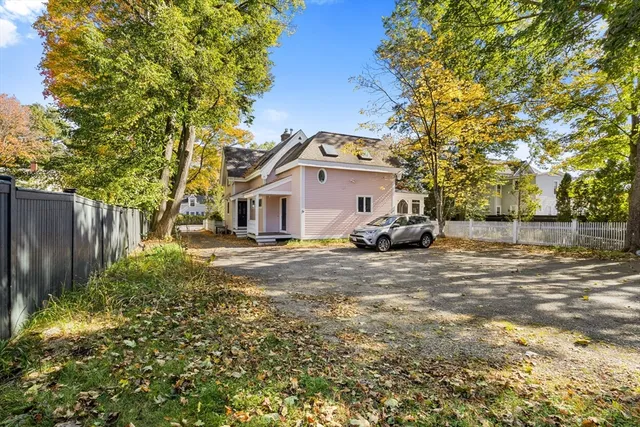a view of a white house with a large tree