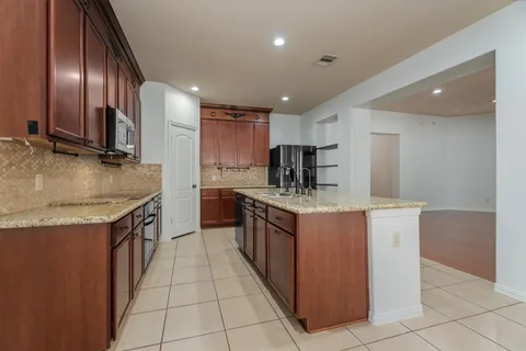 a kitchen with granite countertop a sink and cabinets