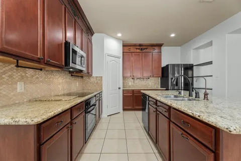 a kitchen with stainless steel appliances granite countertop a sink counter space cabinets and a large window