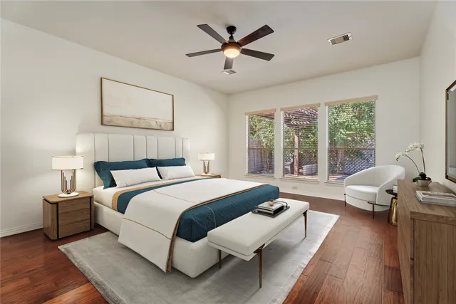 a spacious bedroom with a bed and wooden floor