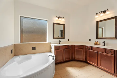 a bathroom with a tub sink and mirror