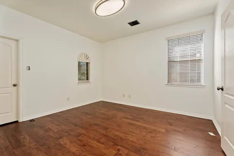 a view of a room with wooden floor and windows