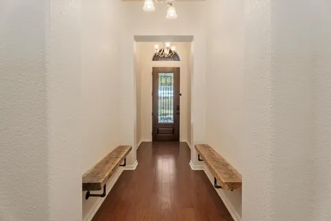 a view of a hallway with wooden floor and staircase