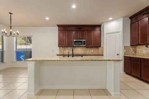 a kitchen with stainless steel appliances granite countertop a sink and a refrigerator