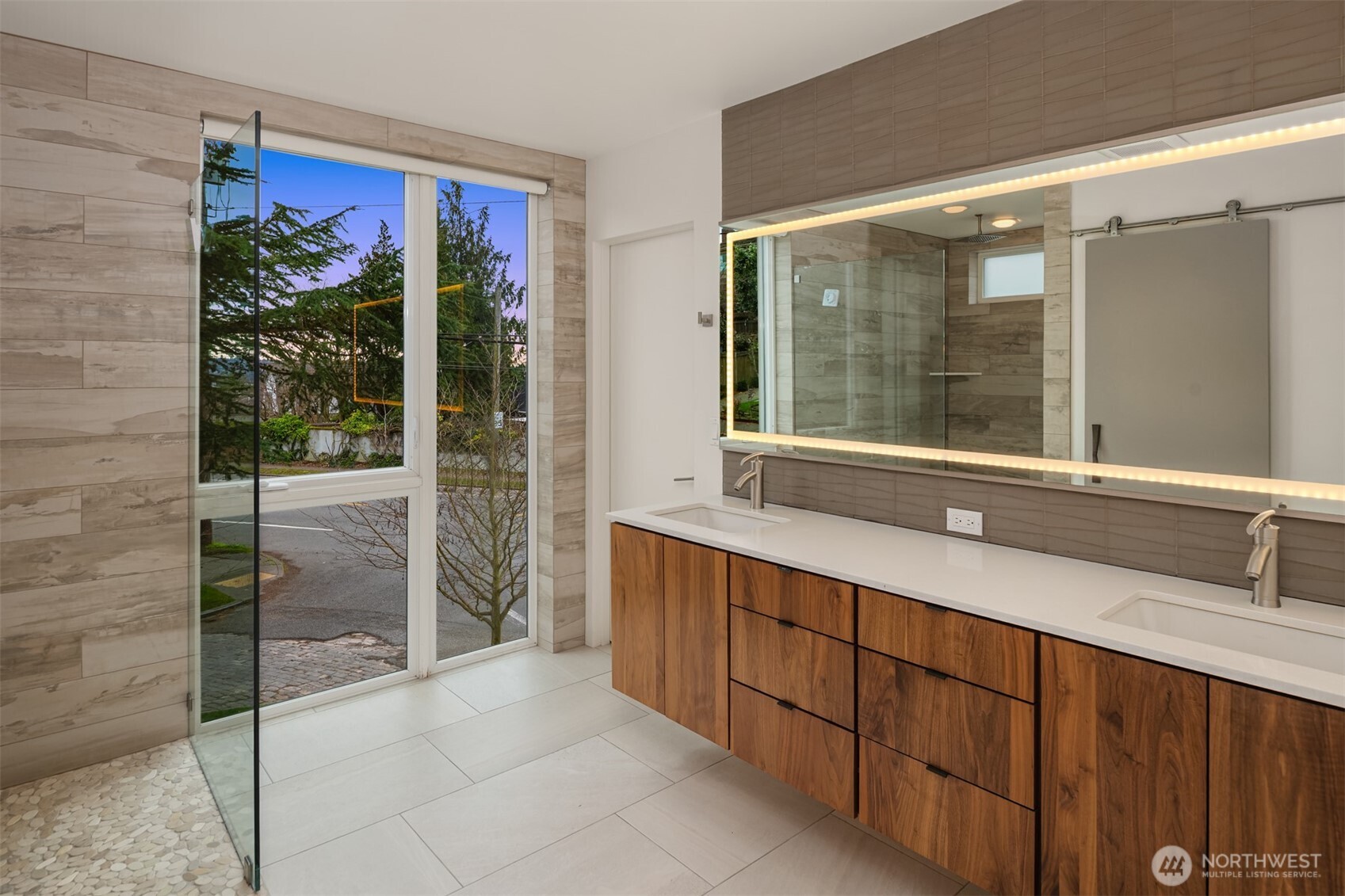 1400 Olympic Way West Seattle, WA 98119 - Photo 14 of 40 a bathroom with a double vanity sink a large mirror and a glass door shower