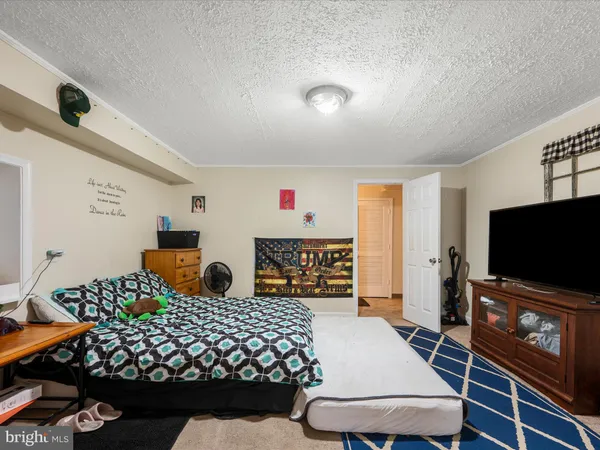 a bedroom with a bed and a flat tv screen on dresser