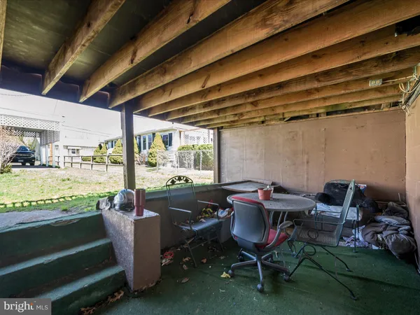 a view of a livingroom with wooden floor and a bathroom