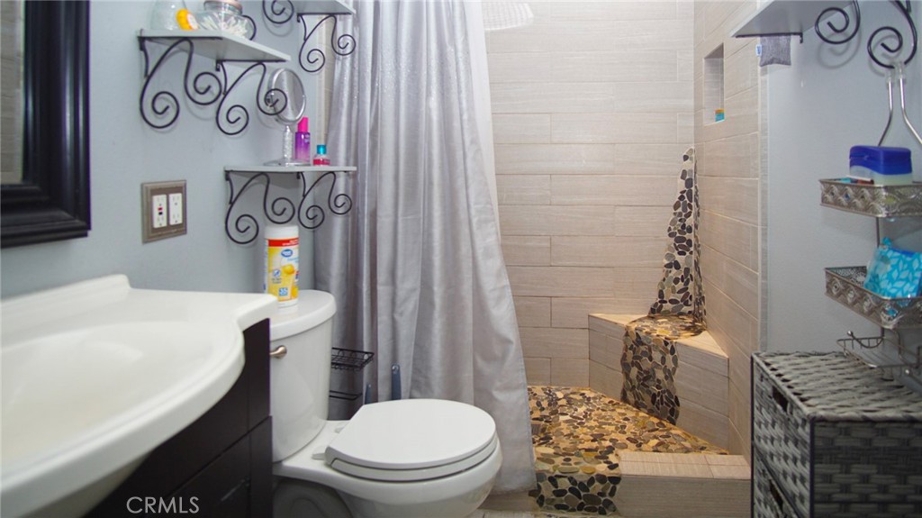 911 East Evergreen Avenue Santa Maria, CA 93454 - Photo 23 of 48 a bathroom with a granite countertop toilet and a sink