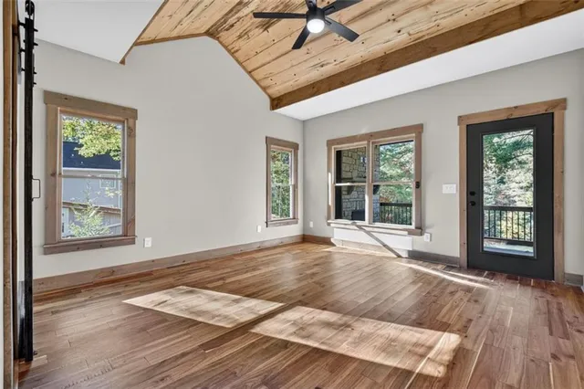 a view of an empty room with a fireplace and a window