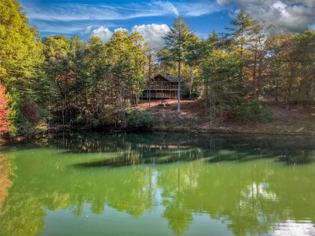 a view of an empty room with wooden floor and a fireplace