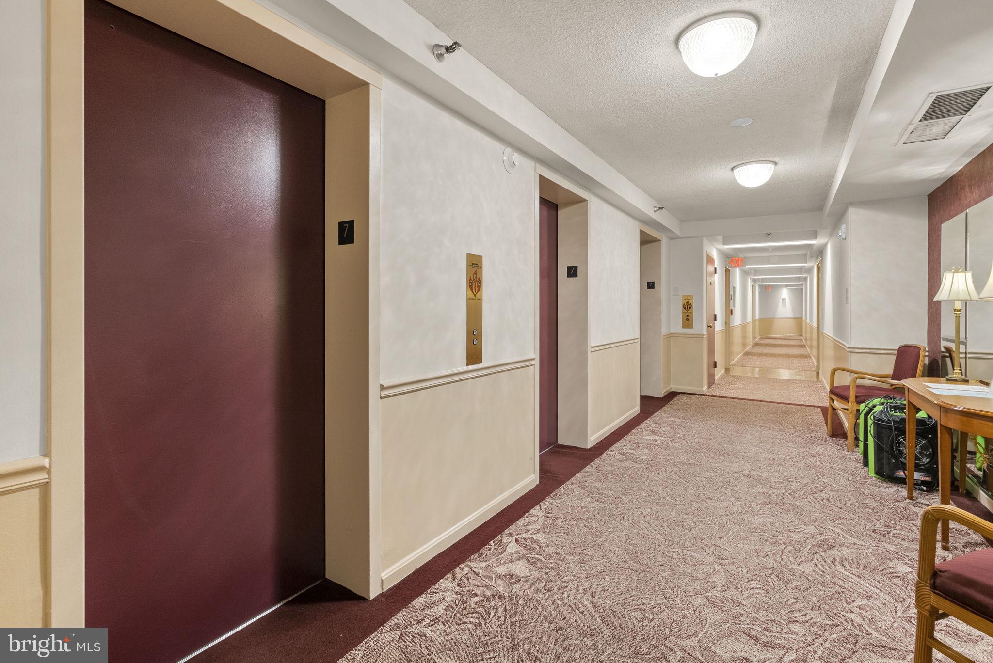 15101 Interlachen Drive, Unit 1705 Silver Spring, MD 20906 - Photo 13 of 17 a view of a hallway with furniture and refrigerator