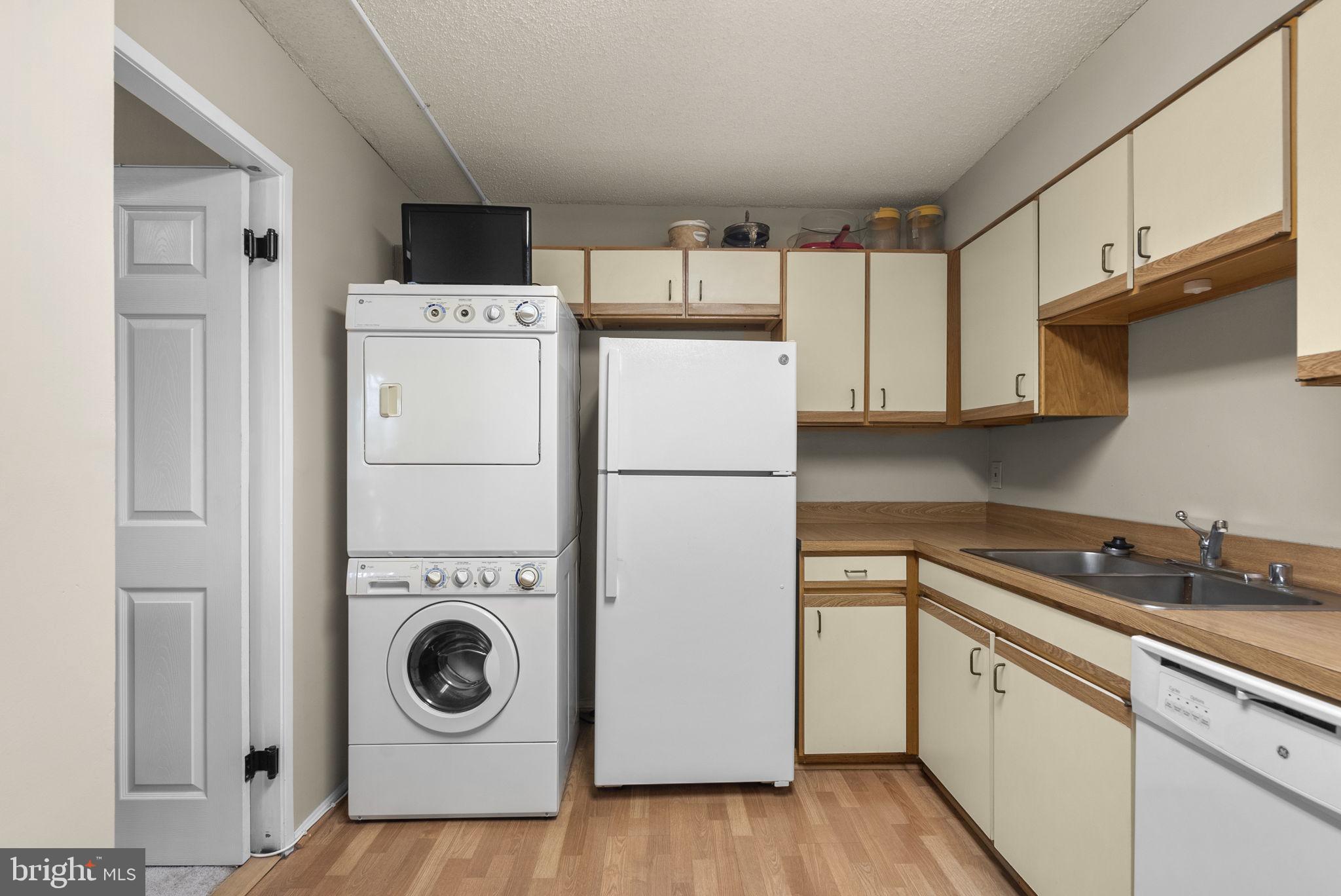 15101 Interlachen Drive, Unit 1705 Silver Spring, MD 20906 - Photo 8 of 17 a kitchen with a refrigerator a washer and dryer