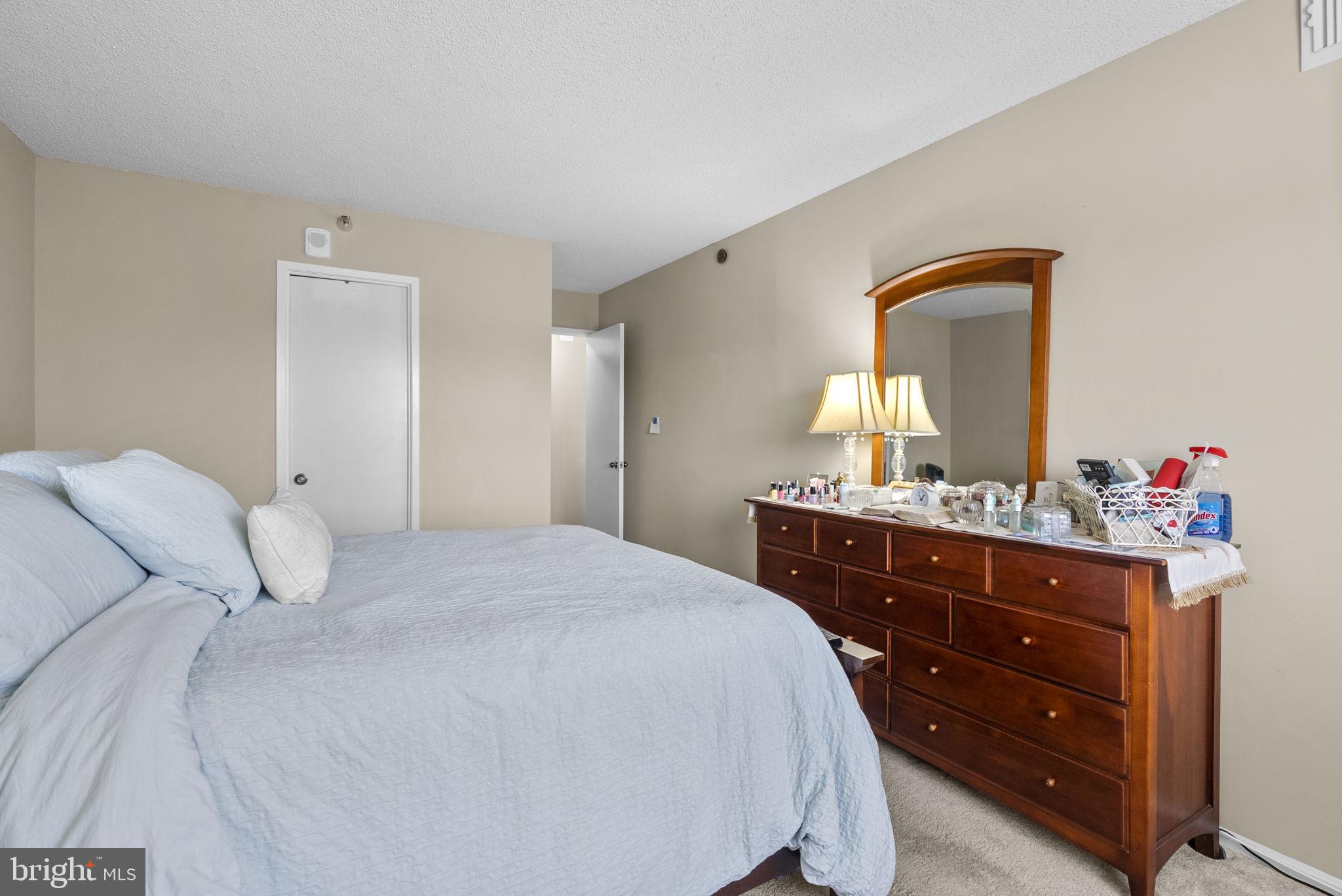 15101 Interlachen Drive, Unit 1705 Silver Spring, MD 20906 - Photo 10 of 17 a bedroom with a bed and a dresser