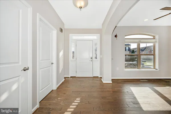 a view of a hallway with wooden floor and a window