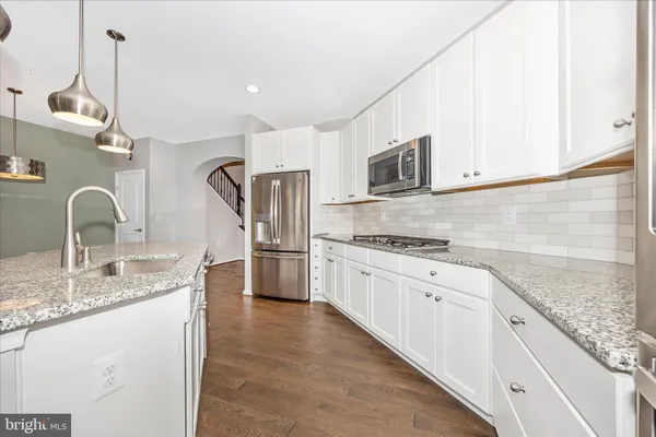 a kitchen with stainless steel appliances granite countertop a sink and a refrigerator