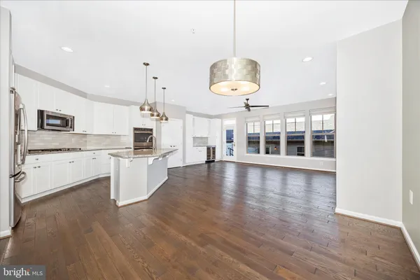 a large kitchen with kitchen island a large counter space and stainless steel appliances