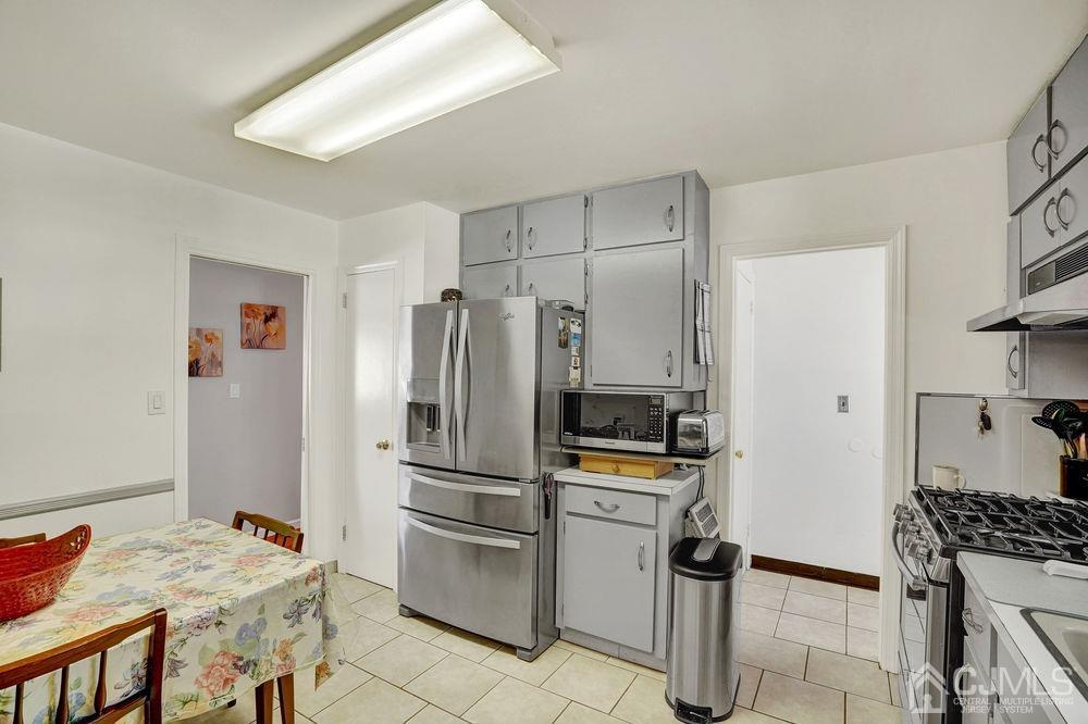1 Sulliman Road Edison, NJ 08817 - Photo 8 of 24 a kitchen with a refrigerator a stove a sink and a dining table