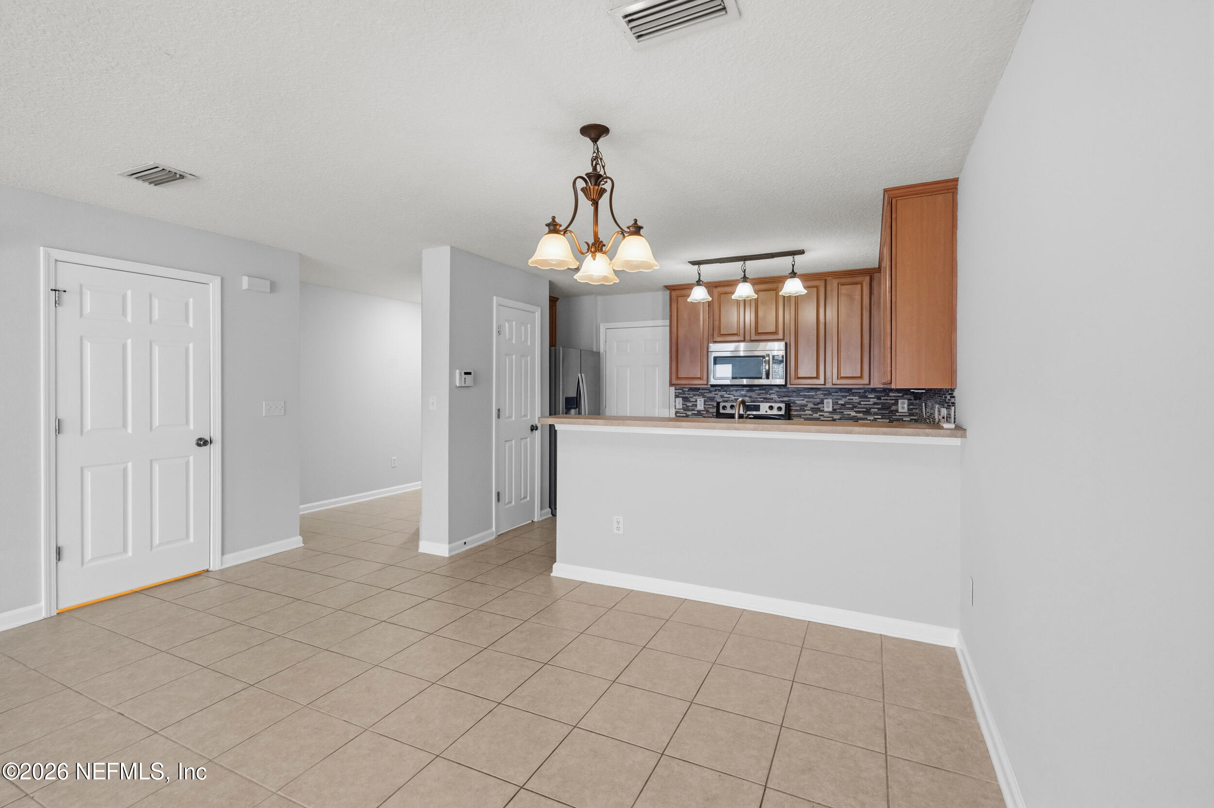 6700 Bowden Road, Unit 1004 Jacksonville, FL 32216 - Photo 4 of 25 a view of a kitchen cabinets and chandelier