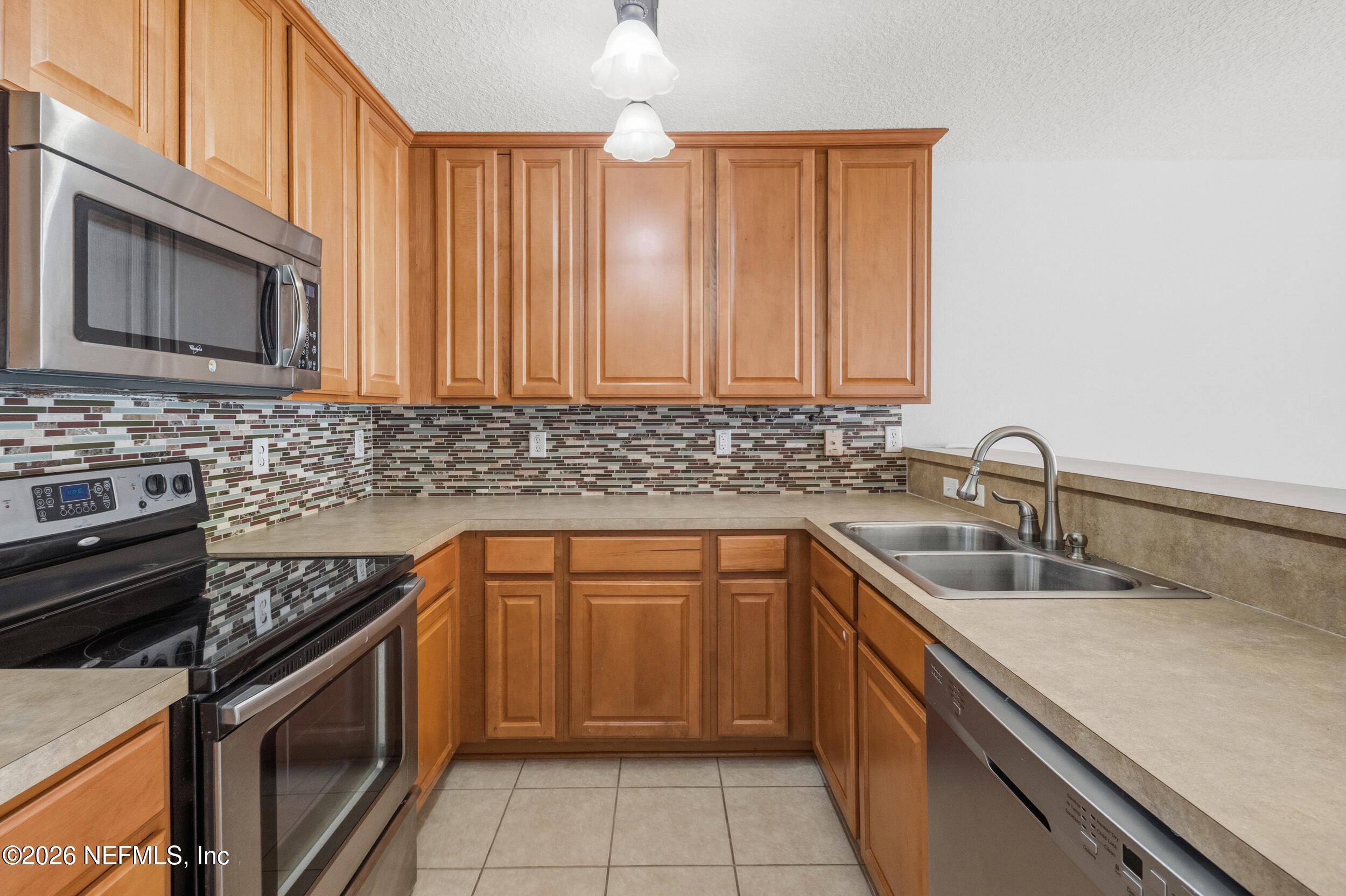 6700 Bowden Road, Unit 1004 Jacksonville, FL 32216 - Photo 8 of 25 a kitchen with a sink stove and cabinets