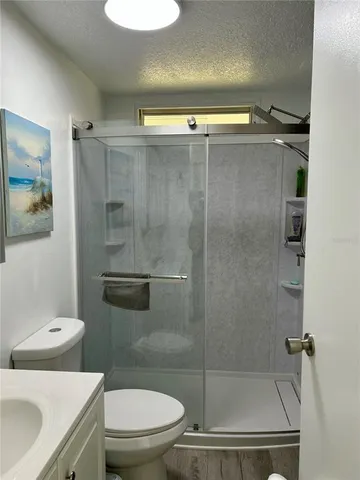 a bathroom with a shower a toilet and a sink