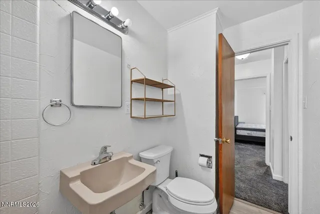 a bathroom with a toilet sink and mirror