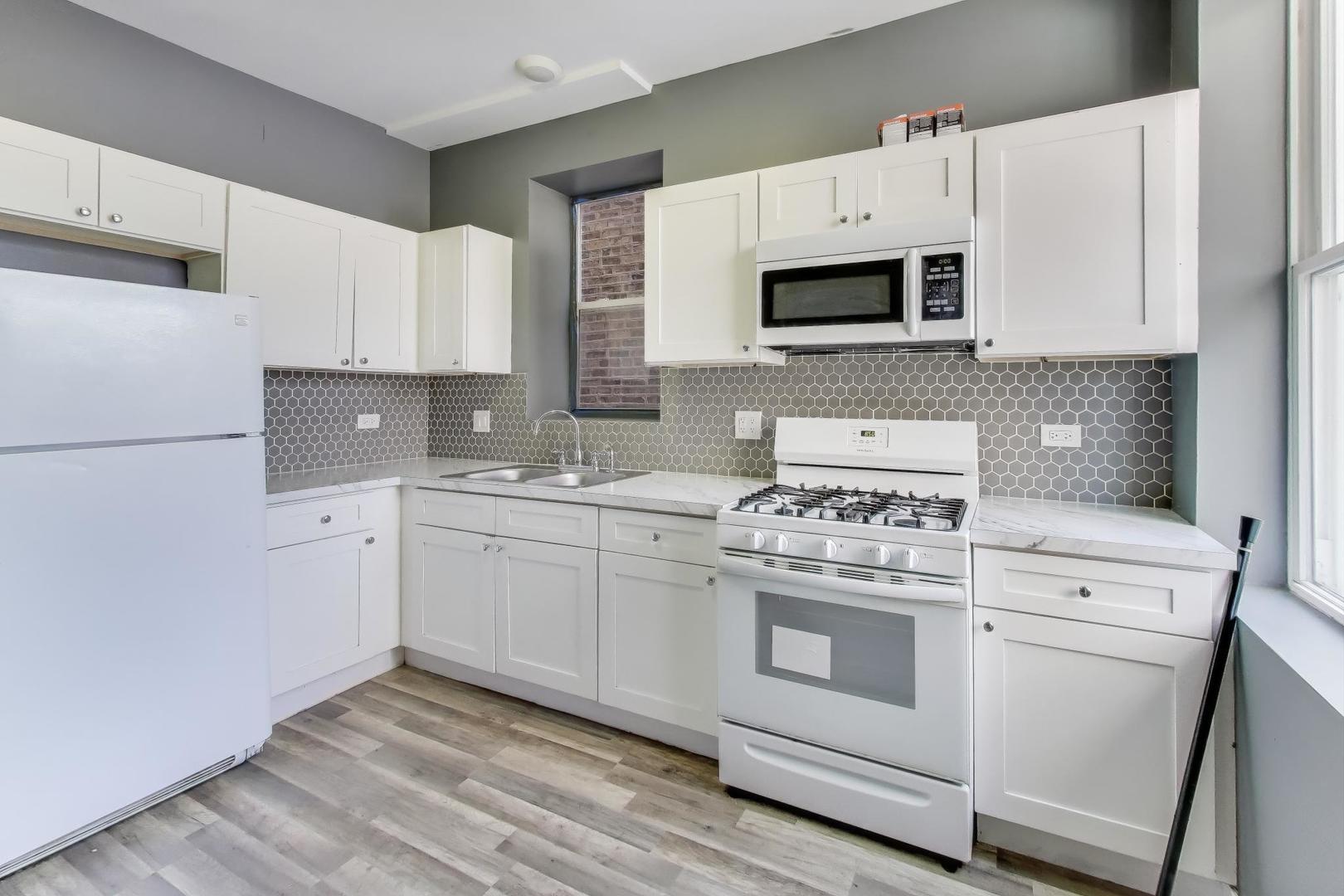 6624 South Rhodes Avenue Chicago, IL 60637 - Photo 6 of 23 a kitchen with white cabinets and white appliances
