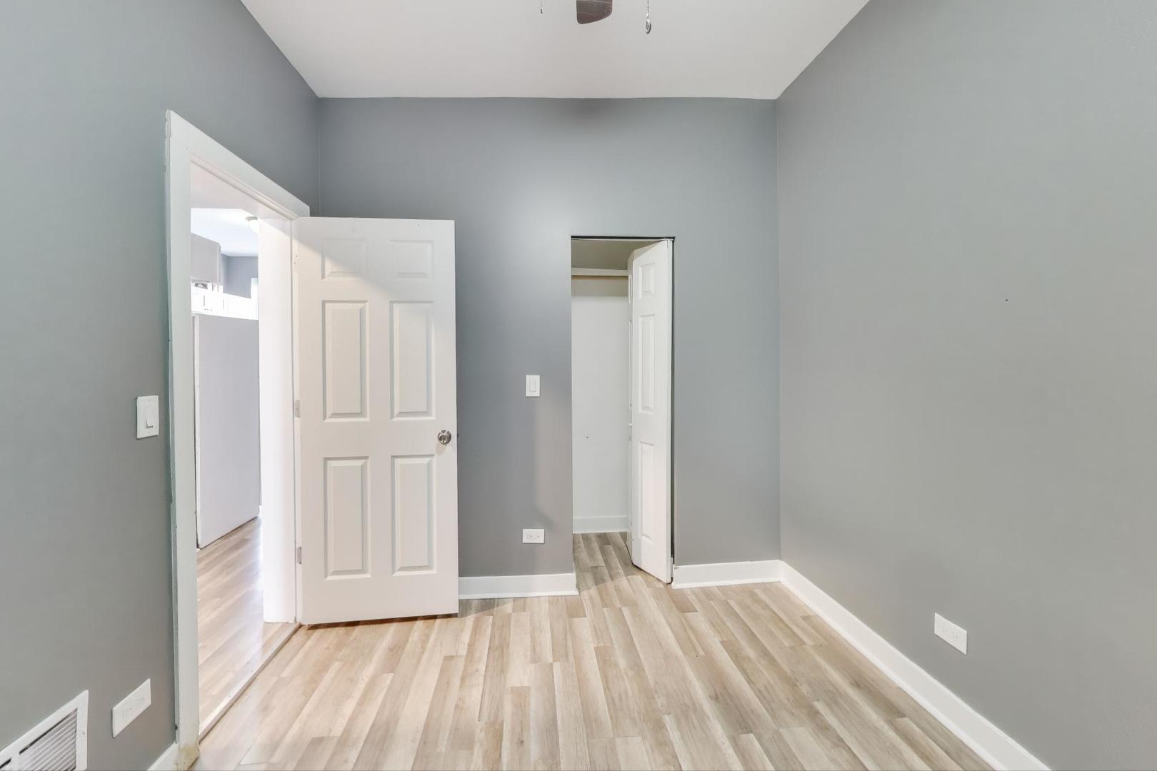 6624 South Rhodes Avenue Chicago, IL 60637 - Photo 9 of 23 a view of an empty room with wooden floor and a window