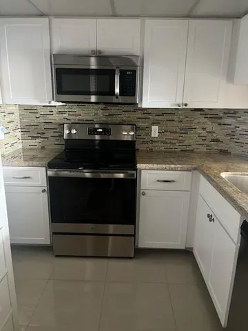 a kitchen with microwave stove and cabinets