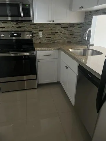 a kitchen with stainless steel appliances a sink stove and cabinets