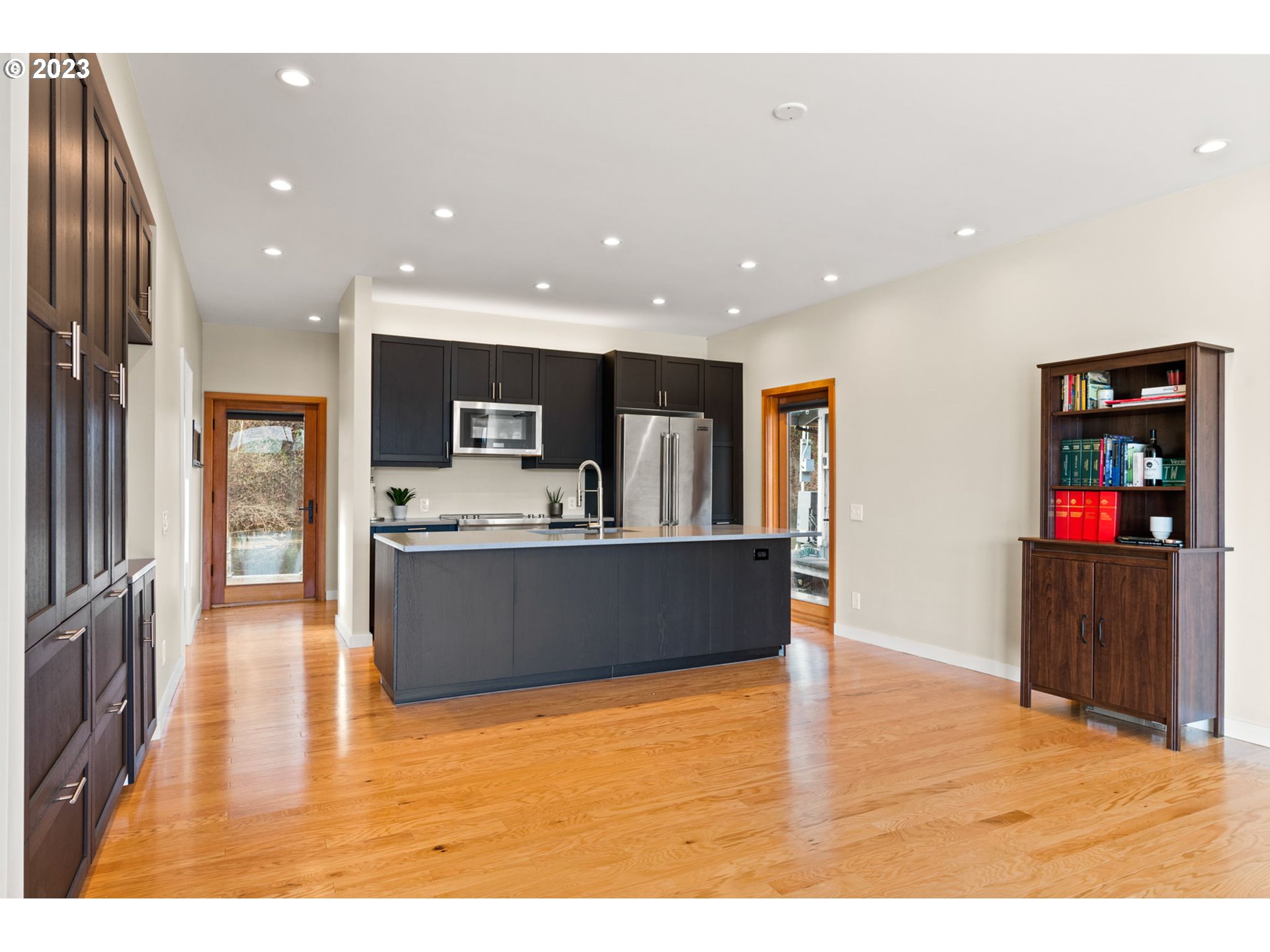 14974 Northwest Mill Road Portland, OR 97231 - Photo 16 of 29 a living room with stainless steel appliances kitchen island granite countertop a refrigerator a stove top oven and a sink