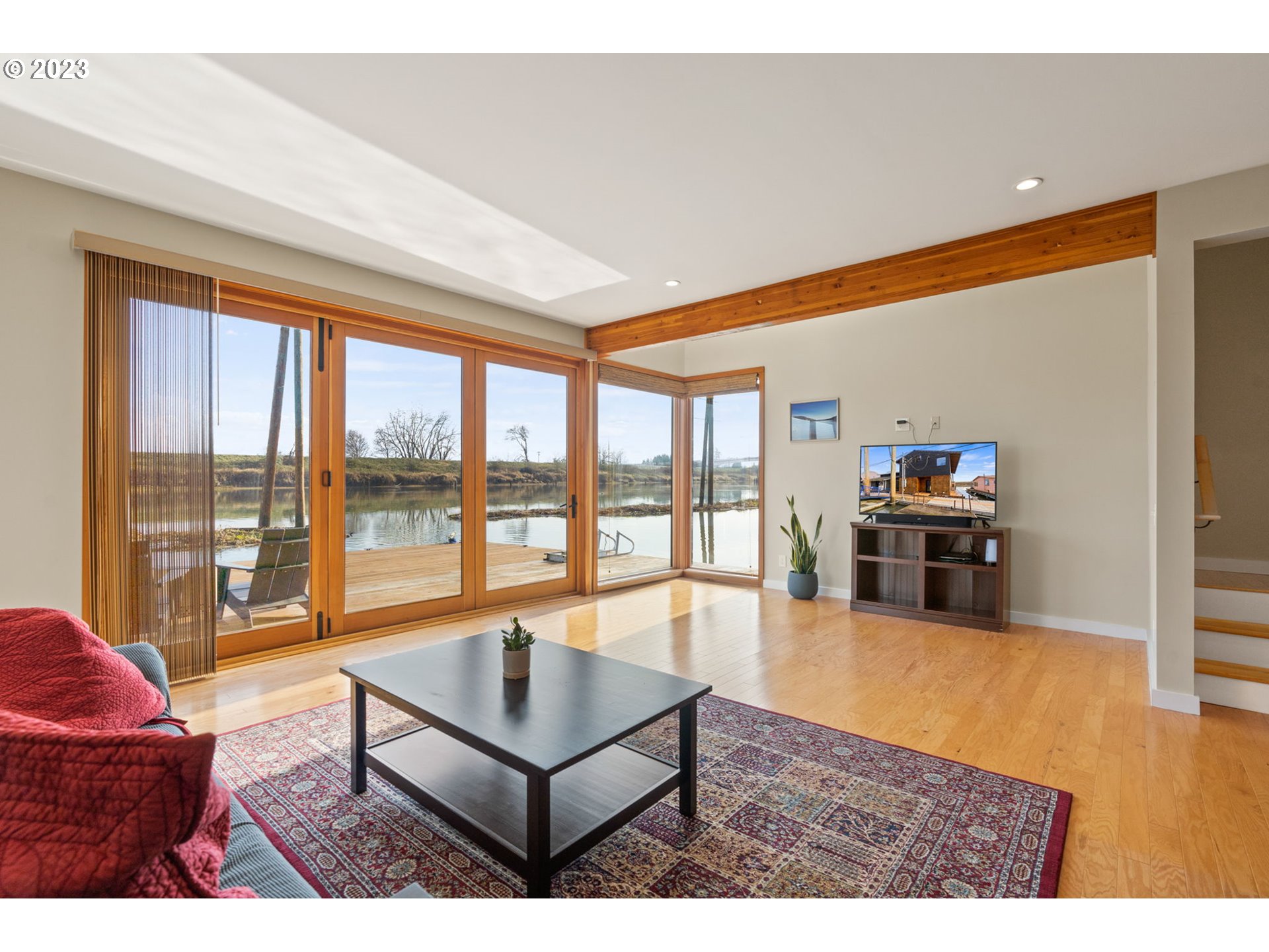 14974 Northwest Mill Road Portland, OR 97231 - Photo 8 of 29 a living room with furniture a flat screen tv and a floor to ceiling window