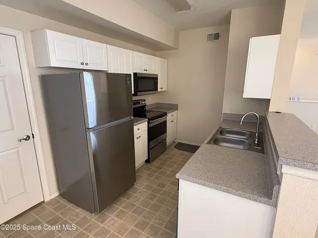 a kitchen with a refrigerator sink stove and cabinets