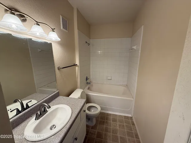 a bathroom with a sink a toilet a mirror and shower