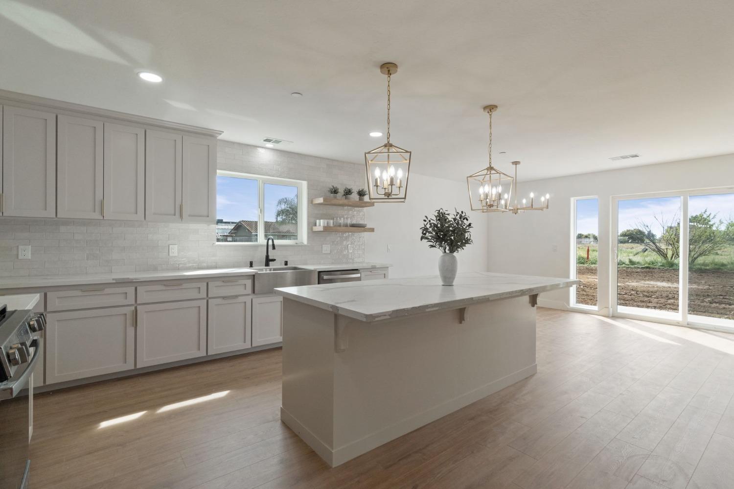 25918 Tanforan Drive Madera, CA 93638 - Photo 12 of 37 a kitchen with stainless steel appliances granite countertop a sink a oven a refrigerator and white cabinets