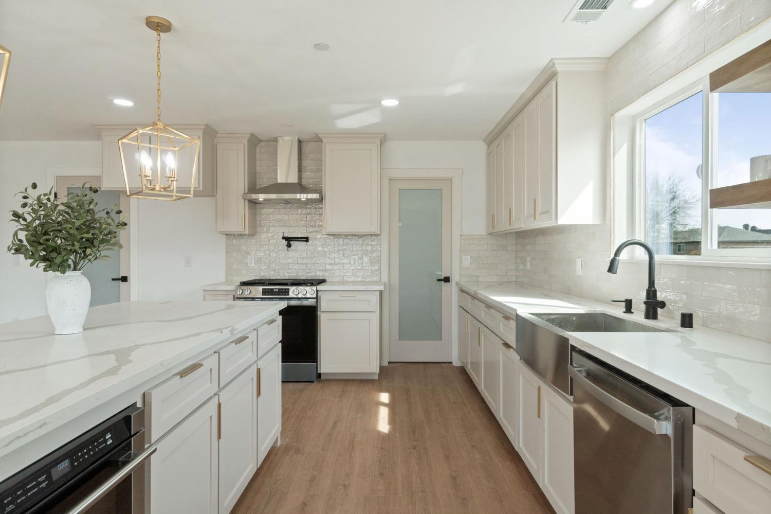 25918 Tanforan Drive Madera, CA 93638 - Photo 16 of 37 a kitchen with a sink stove cabinets and wooden floor