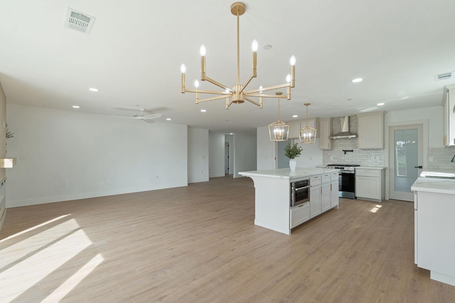 25918 Tanforan Drive Madera, CA 93638 - Photo 19 of 37 a view of kitchen with kitchen island white cabinets and stainless steel appliances