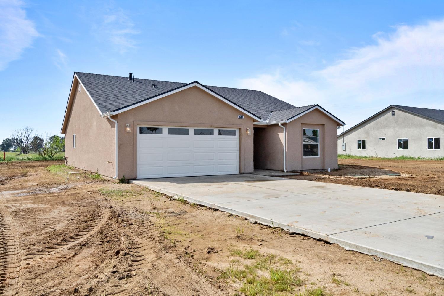 25918 Tanforan Drive Madera, CA 93638 - Photo 2 of 37 a front view of a house with a yard and garage