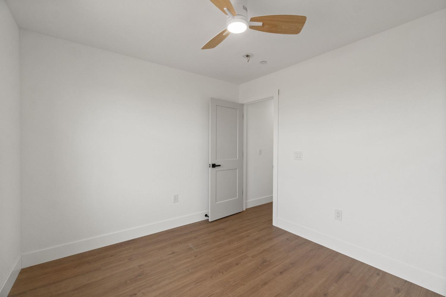 25918 Tanforan Drive Madera, CA 93638 - Photo 24 of 37 an empty room with wooden floor and windows