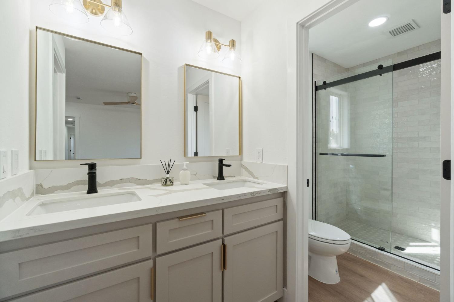 25918 Tanforan Drive Madera, CA 93638 - Photo 31 of 37 a bathroom with a granite countertop sink toilet and shower