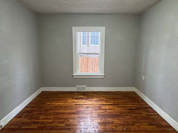 a view of a room with wooden floor and window