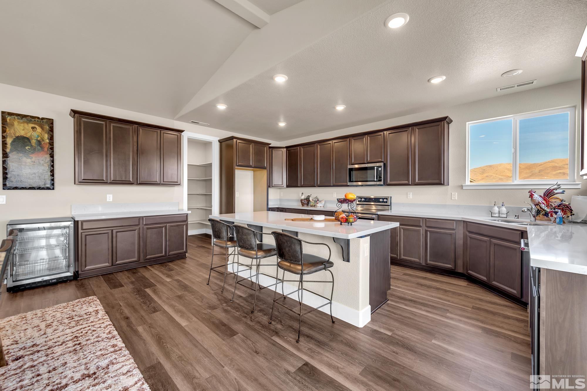 250 Paloma Ranch Court Reno, NV 89510 - Photo 27 of 35 a kitchen with stainless steel appliances kitchen island granite countertop a stove a sink and a microwave