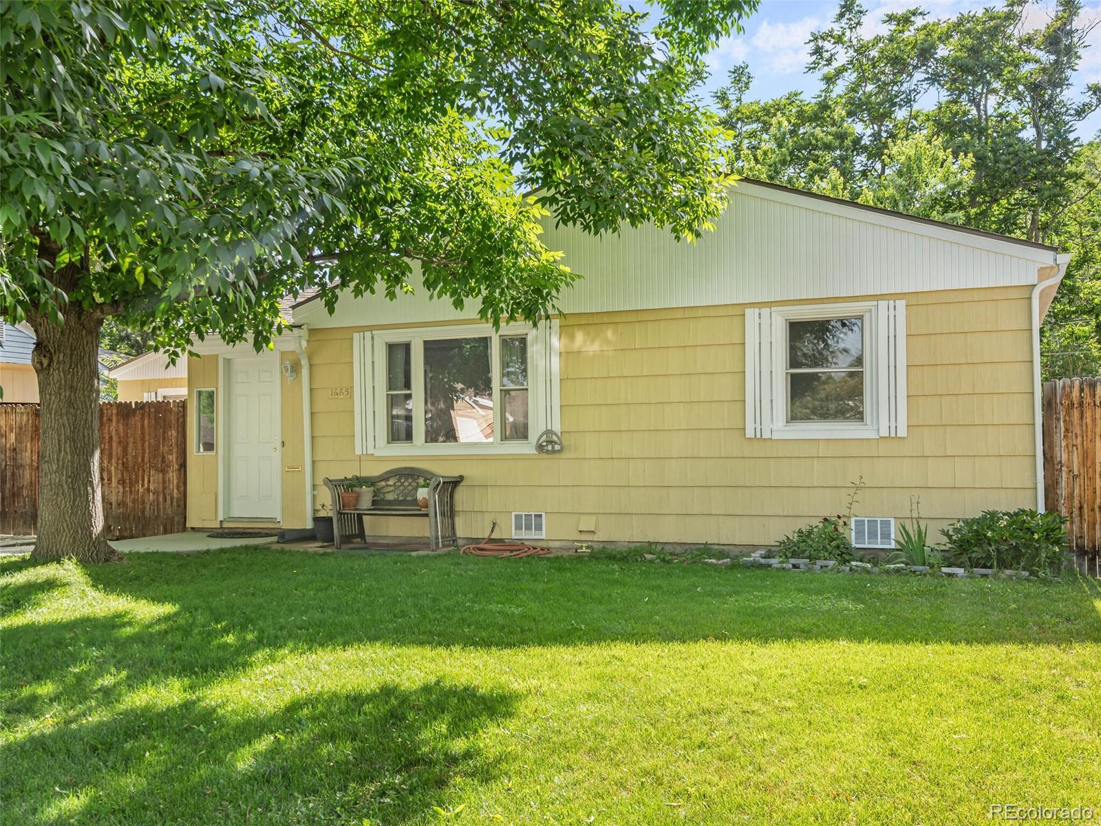 a front view of a house with a yard and trees