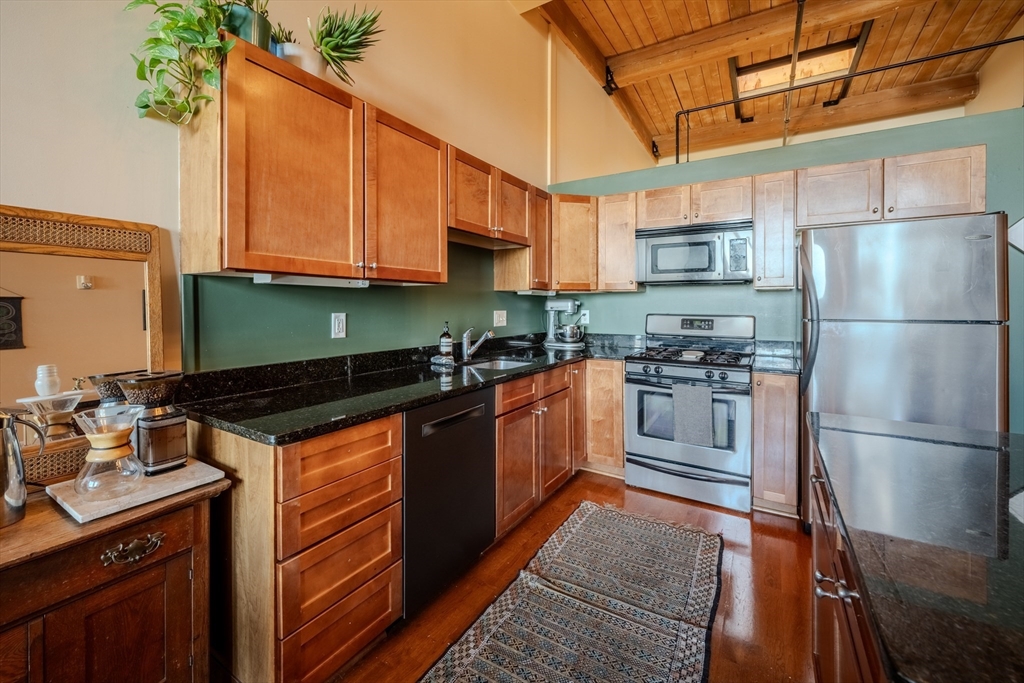 160 Fremont Street, Unit 405 Worcester, MA 01603 - Photo 12 of 34 a kitchen with stainless steel appliances granite countertop a refrigerator a stove and a sink