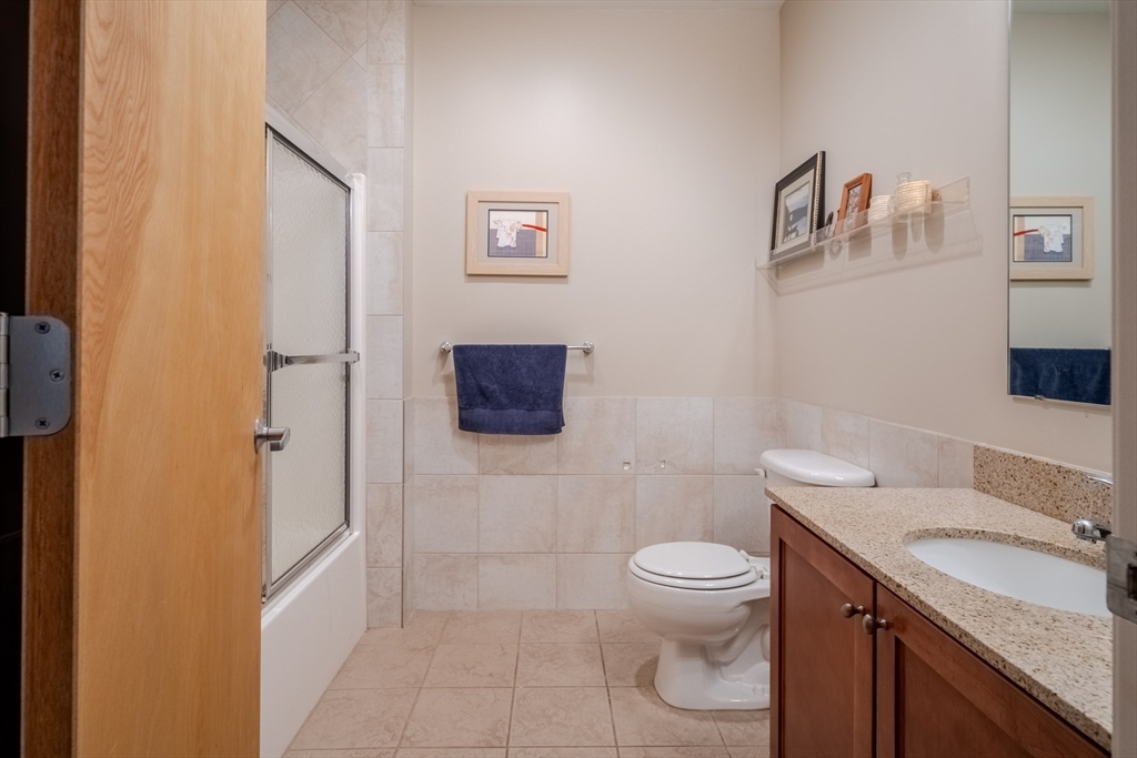 160 Fremont Street, Unit 405 Worcester, MA 01603 - Photo 25 of 34 a bathroom with a granite countertop toilet sink and mirror